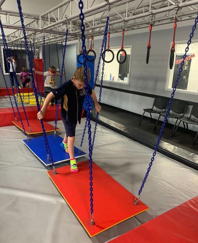 Kid on swinging chain obstacle